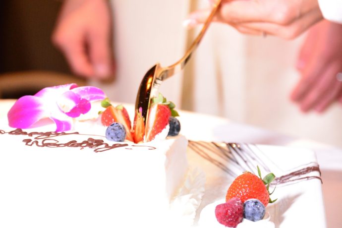 画像：大きなスプーンでウエディングケーキを掬っているところ