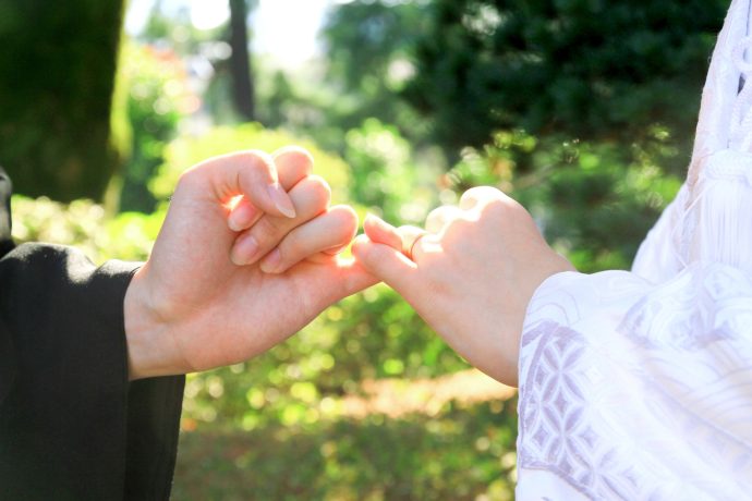 画像：指切りげんまんをする和装姿の新郎新婦