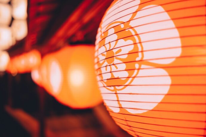 画像：オレンジ色の提灯が夜の街に明かりを灯している