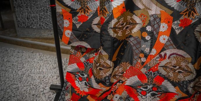 画像：衣桁にかけられた黒地に赤い模様の着物