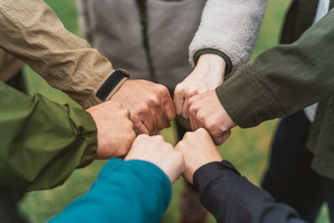 画像：6人でこぶしを突き合わせている