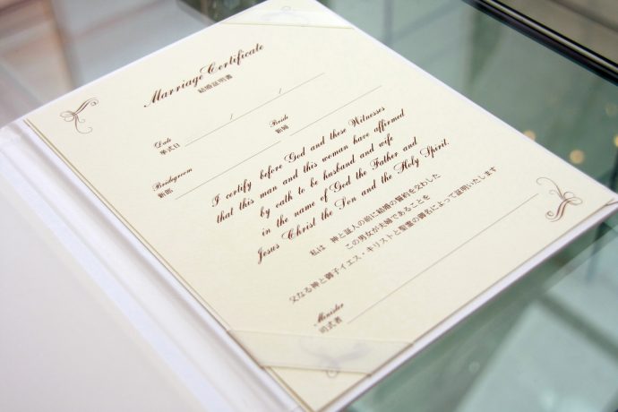 画像：ガラスのテーブルの上に乗った結婚証明書