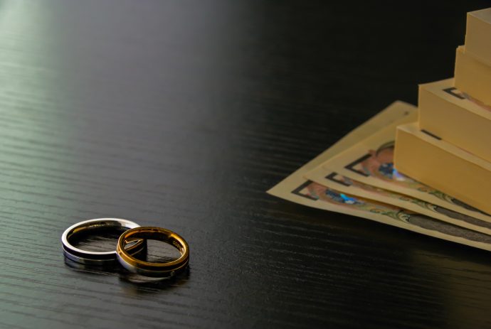 結婚指輪と万札の写真