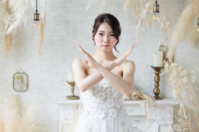 画像：体の前で腕をクロスさせる花嫁
