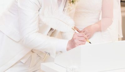 結婚証明書にサインしている新郎新婦の写真