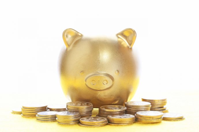 金色の豚の貯金箱とコインの写真