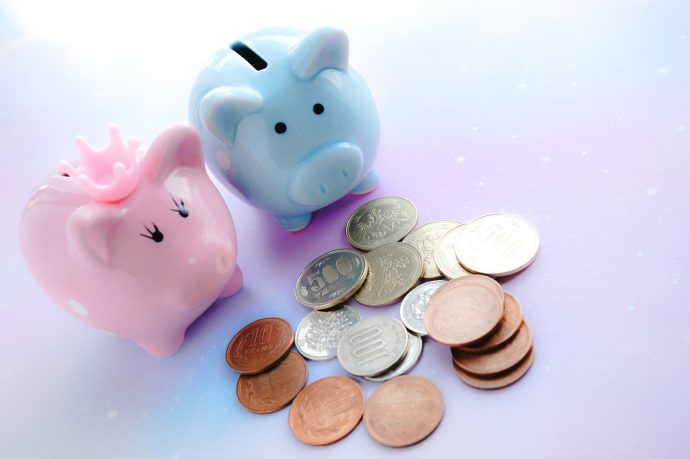 ピンクとブルーの豚の貯金箱と小銭の写真