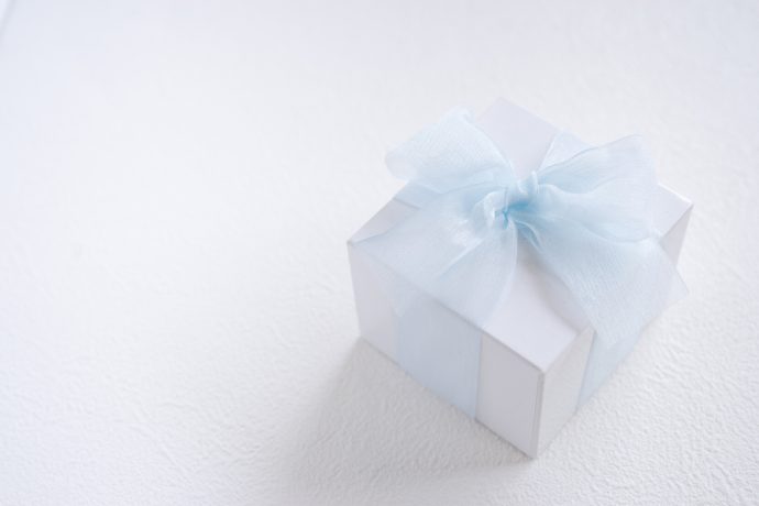 青いリボンのかかった白いプレゼント箱の写真