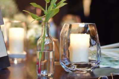 ガラスの花瓶とキャンドルと植物の写真