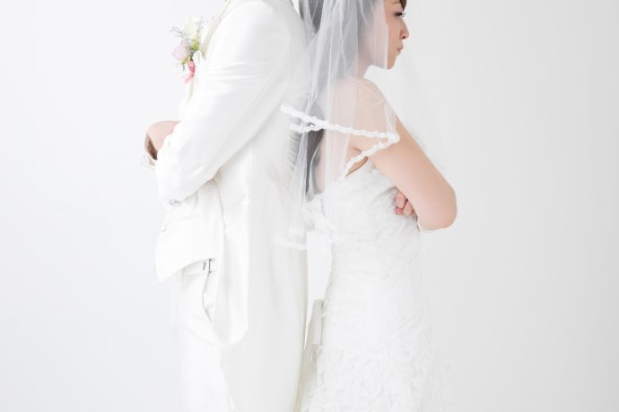 腕を組み背中を向け合う新郎新婦