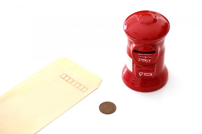 茶封筒と10円玉と赤いポストの置物