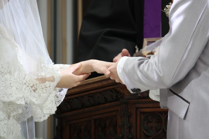 祭壇にて結婚指輪を嵌める新郎