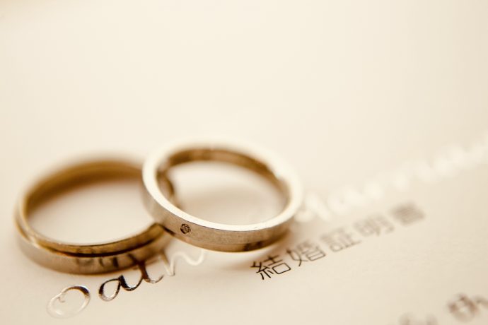 結婚証明書の上に置かれた2つの結婚指輪