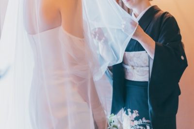 黒留袖の母親がベールダウンを行っている