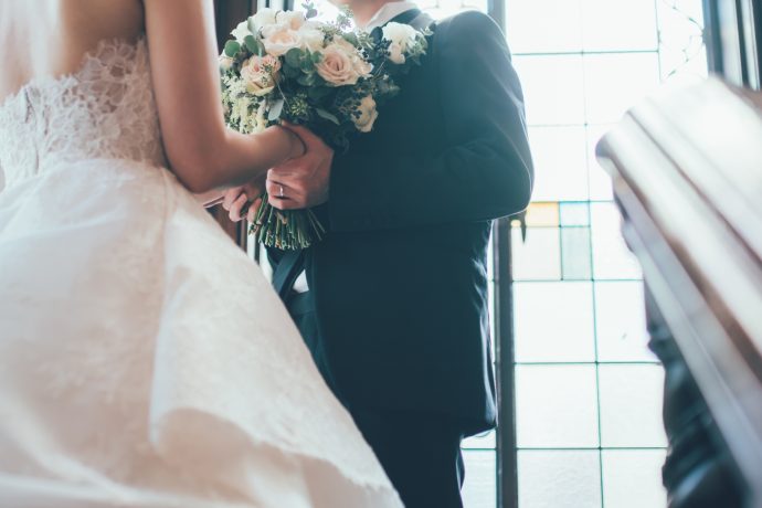 階段の踊り場で花嫁の手を取る花婿