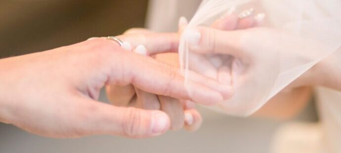 花婿の手に結婚指輪を嵌める花嫁の画像
