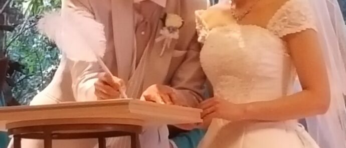 結婚証明書にサインする新郎新婦の画像