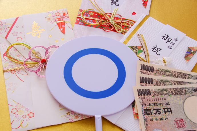 ご祝儀袋と一万円札と丸が書かれた札の画像