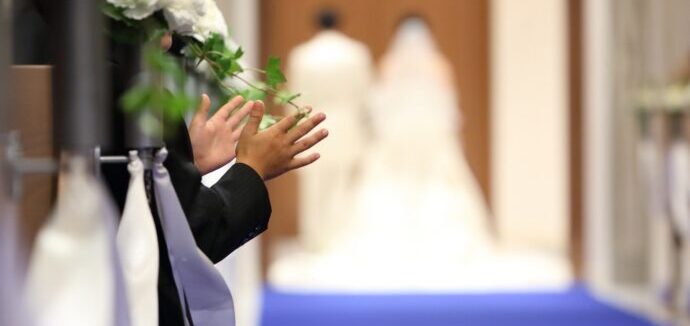 新郎新婦に拍手を送っているゲストの画像