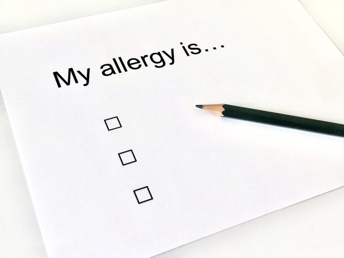 My allergy is...の文字とチェックボックスが3つ書かれた紙と鉛筆の写真