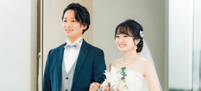 笑顔で並び立つ新郎新婦の画像