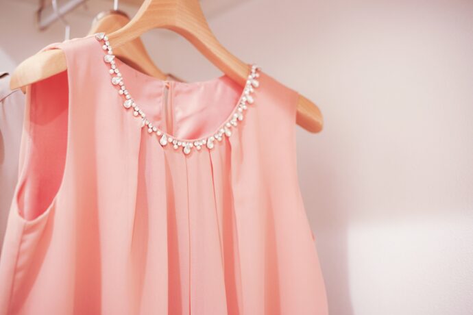 クローゼットの中のハンガーにかかったピンクのドレスの写真