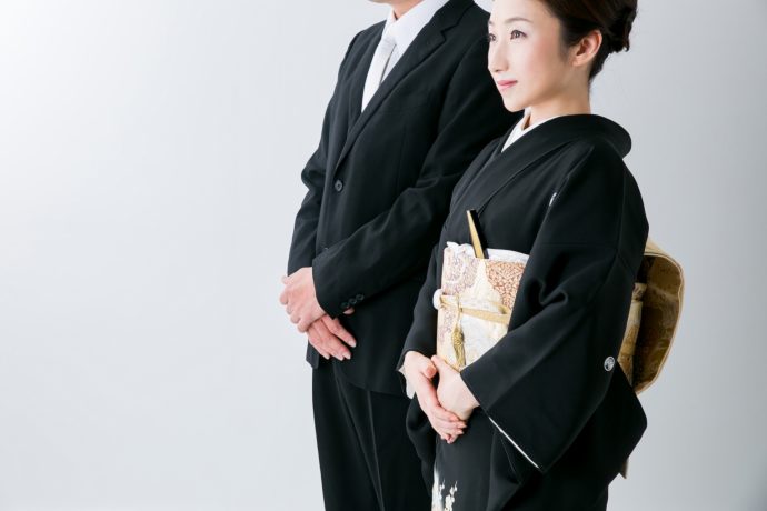 画像：黒留袖の女性とブラックスーツの男性