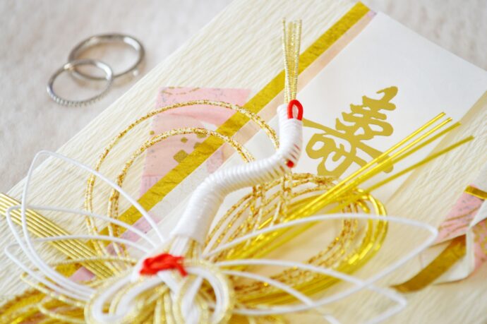 鶴を模った水引のご祝儀袋と結婚指輪の画像
