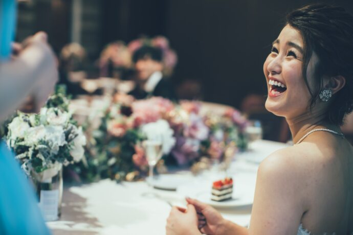 画像：高砂席に置かれた装花と笑顔で振り向く花嫁