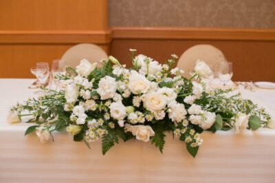画像：高砂席の中央に置かれた白いバラとグリーンの装花