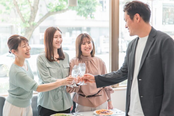 画像：男性と乾杯をする3人の女性