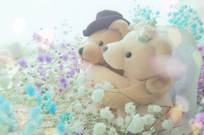 画像：かすみ草の花束の中で抱き合うくまのぬいぐるみ