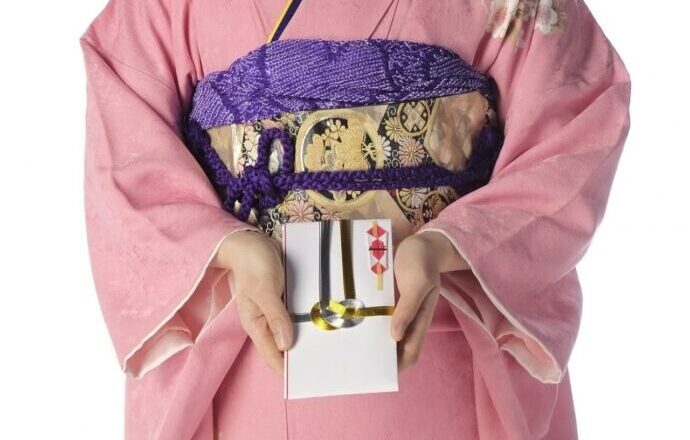画像：ご祝儀袋を差し出す着物の女性の手元