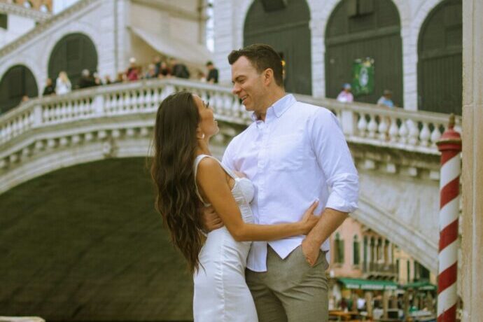 画像：ヴェネツィアの橋の前でポーズを取る男女