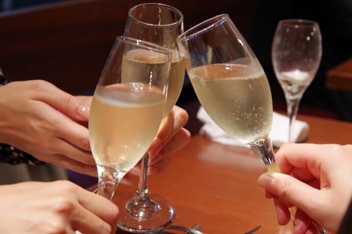 画像：シャンパングラスで乾杯する三人の手元