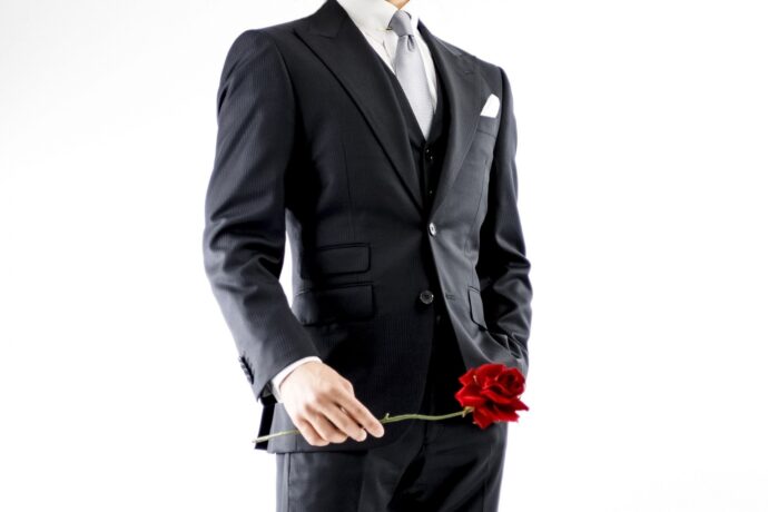 画像：1輪のバラを持ったスーツ姿の男性