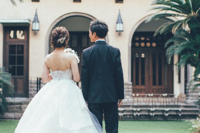 画像：ガーデンで腕を組んでいる花嫁と花婿の後ろ姿