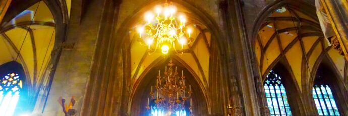 画像：シャンデリアとステンドグラスが輝く教会の内部