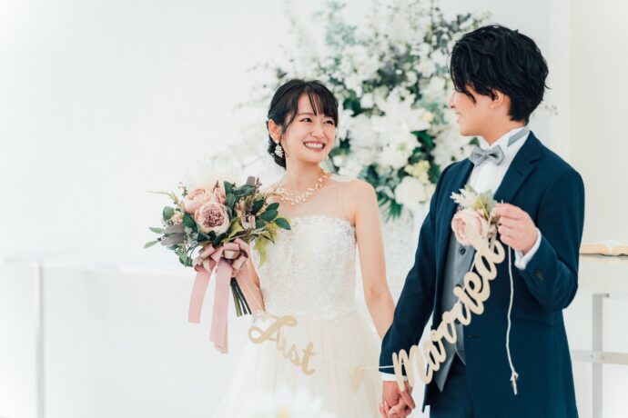 画像：手を繋ぎ笑って見つめ合う花嫁と花婿の前撮り