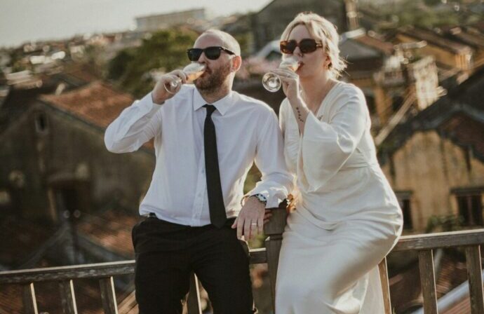 画像：並んでビンをラッパ飲みするサングラスをかけた花婿と花嫁