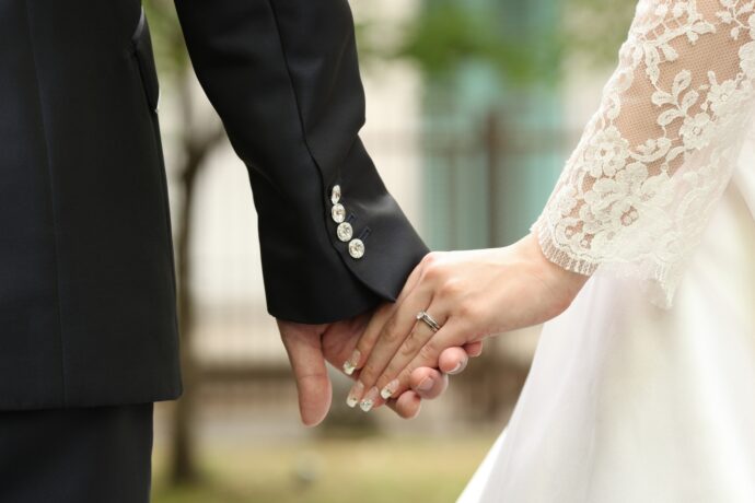 画像：手を繋ぐ花嫁と花婿の手元