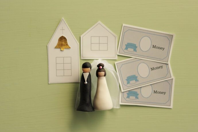 画像：花嫁と花婿のフィギュアと紙でできた教会、お金