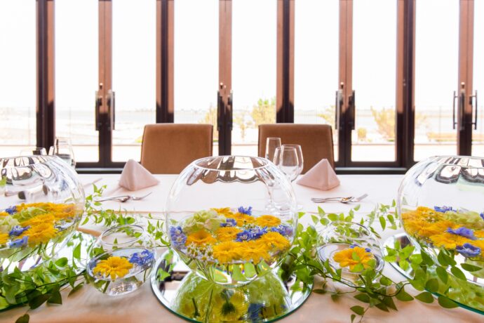 画像：ガラス瓶に生けられた生花と高砂席