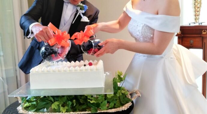 画像：ウエディングケーキにソースを注ぐ新郎新婦