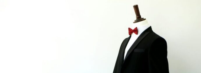 画像：タキシードを着て赤い蝶ネクタイを付けたマネキン