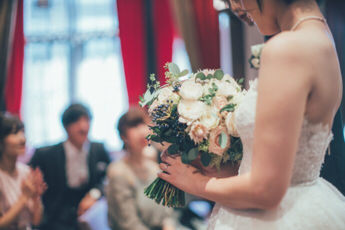 画像：ブーケを持ちゲストの前に立つ花嫁の横姿