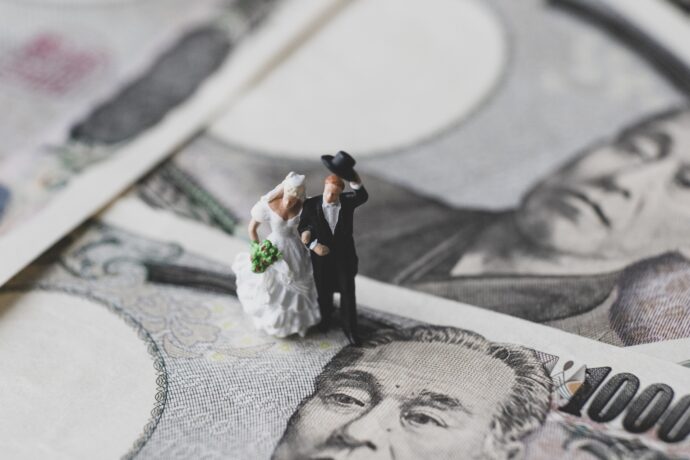 画像：敷かれた1万円札の上に置かれた花嫁と花婿の置物