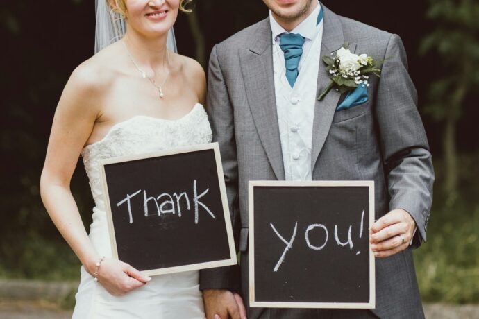 画像：Thank Youと書かれた黒板ボードを持つ新郎新婦