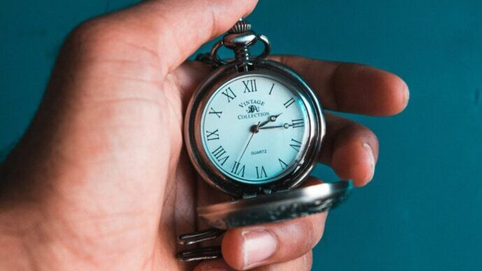 画像：懐中時計を手に持って時間を見ている