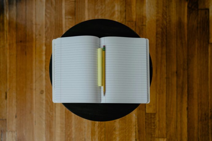 画像：1冊の開いたノートと黄色い鉛筆